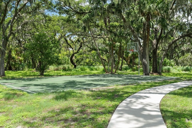 view of home's community with community basketball court and a lawn