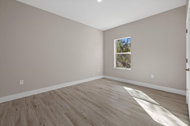 empty room with light wood-style floors and baseboards