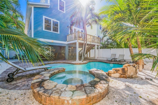 view of pool with fence, a fenced in pool, and an in ground hot tub