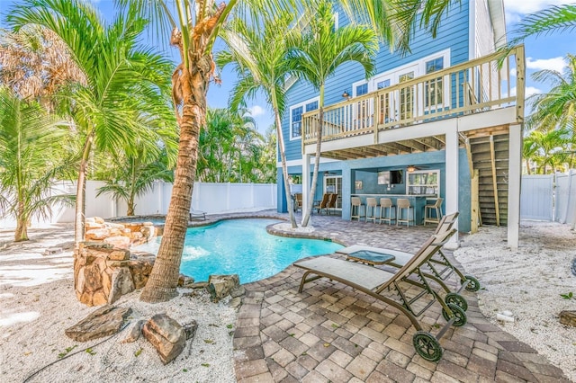 view of swimming pool with outdoor dry bar, a patio, and a fenced backyard