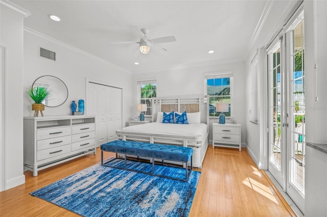 bedroom with crown molding, light wood-type flooring, visible vents, and access to exterior