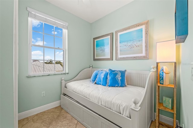 bedroom with light tile patterned floors and baseboards