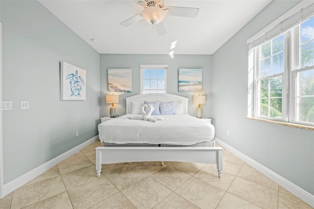 bedroom with light tile patterned floors, a ceiling fan, and baseboards