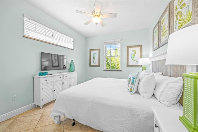 bedroom with light tile patterned floors, ceiling fan, and baseboards