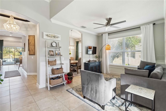 living room featuring arched walkways, ornamental molding, ceiling fan with notable chandelier, and light tile patterned floors