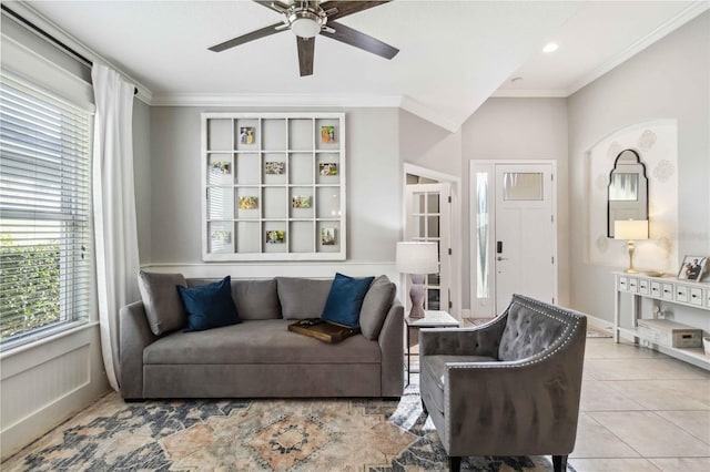 tiled living area with ceiling fan and crown molding