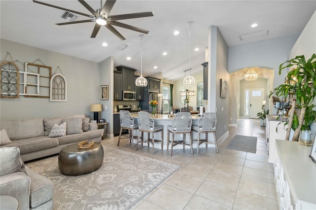 living room with light tile patterned floors, visible vents, arched walkways, a ceiling fan, and vaulted ceiling