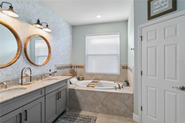 full bath featuring tile patterned flooring, a garden tub, a sink, and wallpapered walls