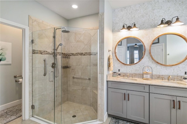 full bath featuring a shower stall, baseboards, and a sink