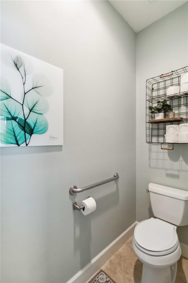 bathroom with toilet, tile patterned flooring, and baseboards