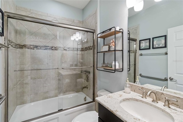 full bathroom featuring toilet, bath / shower combo with glass door, and vanity