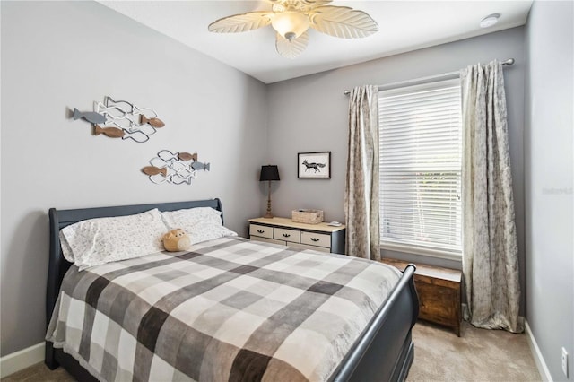 bedroom with a ceiling fan, light colored carpet, and baseboards