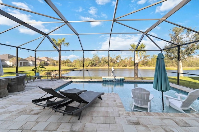 outdoor pool with glass enclosure, a patio area, and a water view