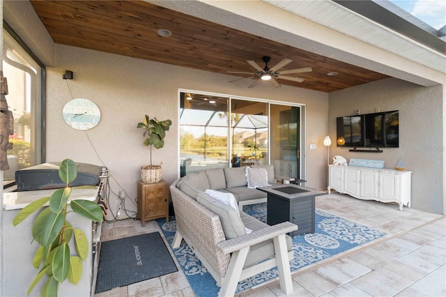 view of patio / terrace with a ceiling fan and an outdoor living space with a fire pit