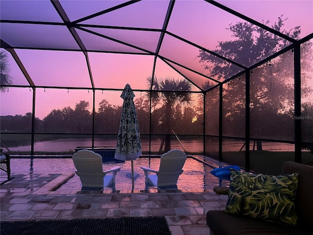 view of patio with glass enclosure and a water view