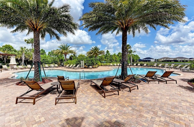 pool with a patio and fence