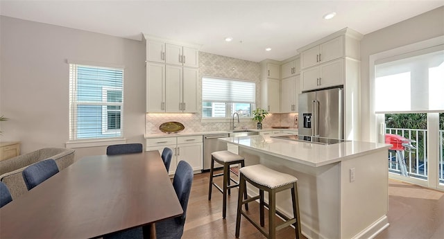 512 Laurel Park Dr, Sarasota, FL 34236 - kitchen with a breakfast bar, a sink, light countertops, appliances with stainless steel finishes, and a center island