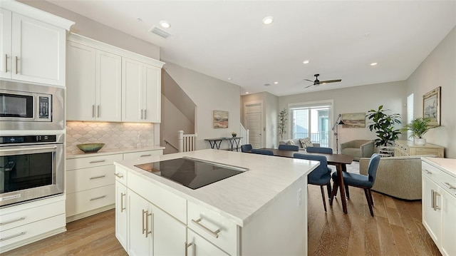 512 Laurel Park Dr, Sarasota, FL 34236 - kitchen featuring a center island, light countertops, appliances with stainless steel finishes, light wood-style floors, and open floor plan