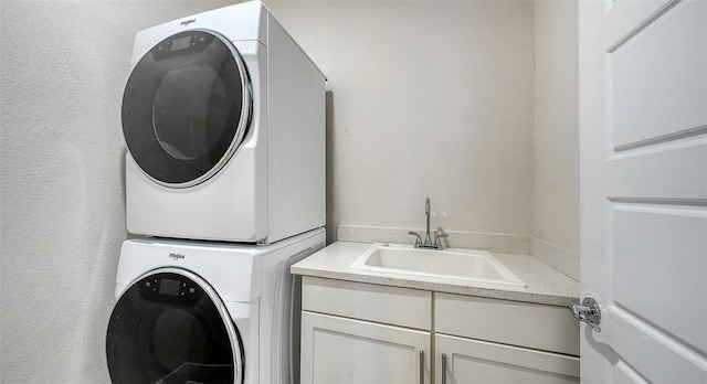 512 Laurel Park Dr, Sarasota, FL 34236 - washroom featuring a textured wall, stacked washer / dryer, cabinet space, and a sink