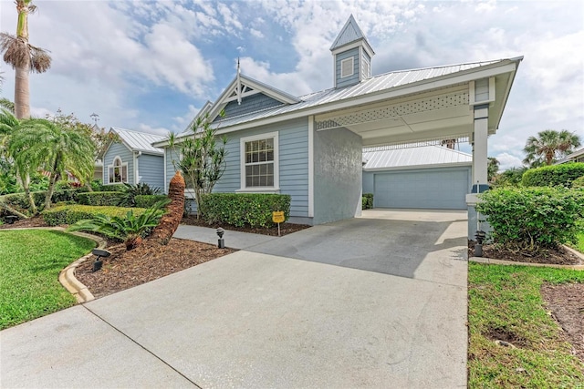 view of front of home featuring a garage, metal roof, and driveway