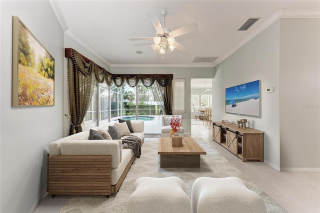 living room with a sunroom, baseboards, a ceiling fan, visible vents, and crown molding