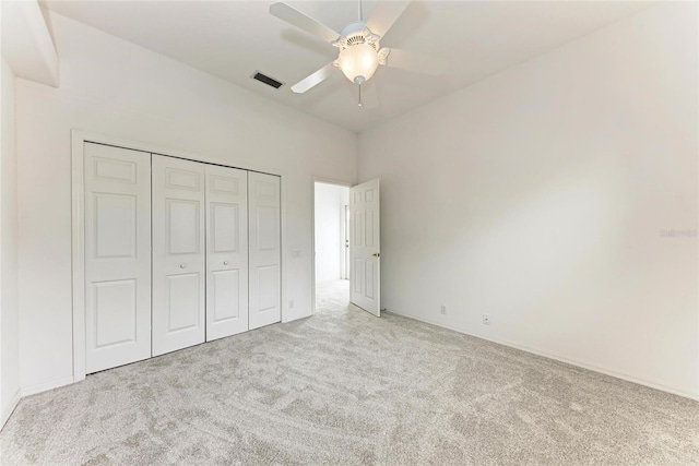 unfurnished bedroom featuring a ceiling fan, visible vents, a closet, and light colored carpet