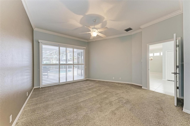 unfurnished room with crown molding, a ceiling fan, visible vents, and light colored carpet