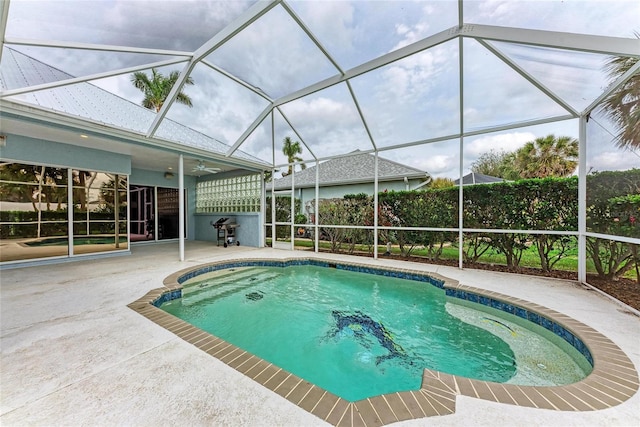 view of swimming pool with a lanai, a patio area, a grill, and a fenced in pool