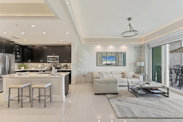 living area with recessed lighting, a raised ceiling, visible vents, and light tile patterned floors