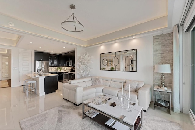 living room featuring light tile patterned floors, a tray ceiling, and recessed lighting