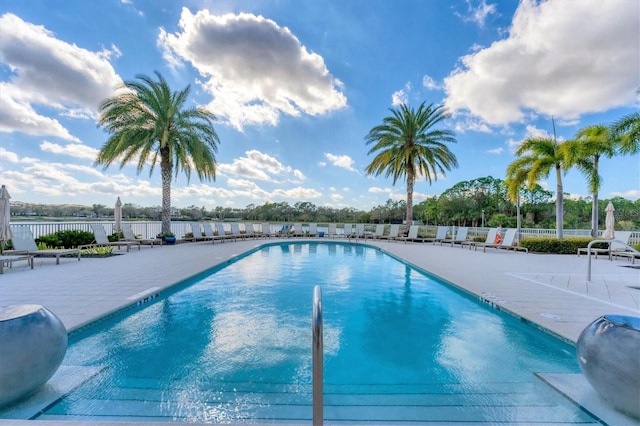 community pool with fence and a patio