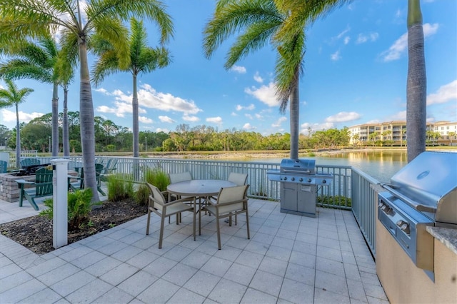 view of patio featuring area for grilling, outdoor dining space, a water view, and exterior kitchen