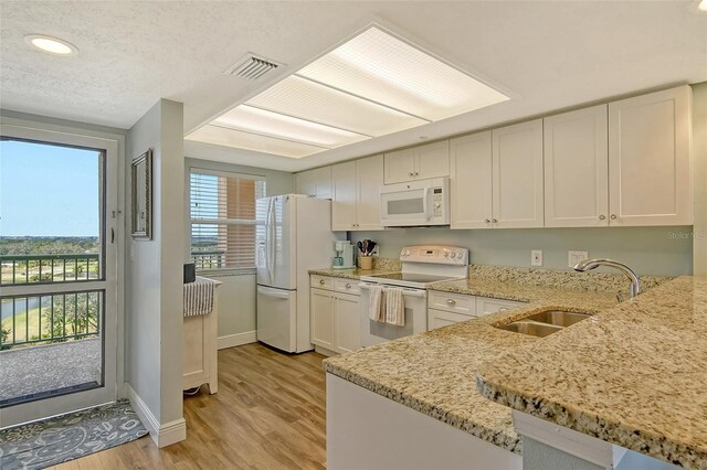 2320 Terra Ceia Bay Blvd Unit 808, Palmetto, FL 34221 - kitchen with white appliances, a sink, light wood-style floors, baseboards, and light stone countertops