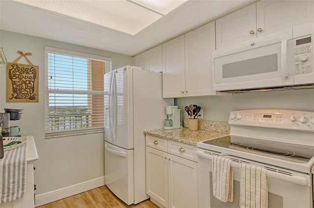 2320 Terra Ceia Bay Blvd Unit 808, Palmetto, FL 34221 - kitchen with white appliances, light wood finished floors, white cabinetry, baseboards, and light stone counters