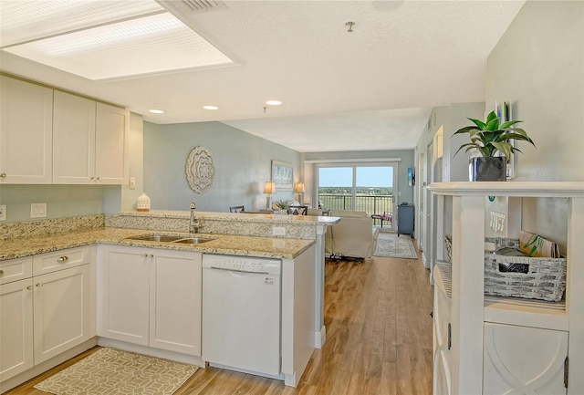 2320 Terra Ceia Bay Blvd Unit 808, Palmetto, FL 34221 - kitchen featuring dishwasher, a sink, open floor plan, a peninsula, and light wood-style floors