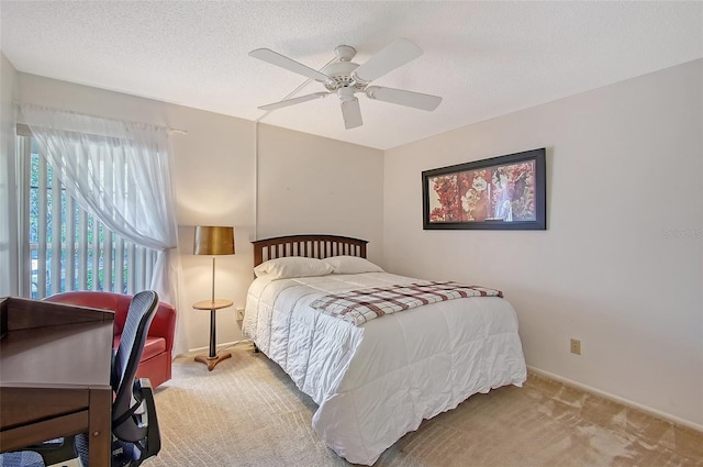 bedroom with a ceiling fan, light colored carpet, a textured ceiling, and baseboards