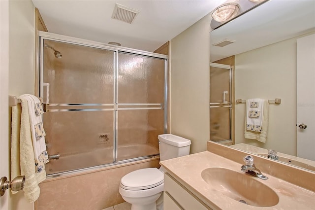 bathroom with toilet, bath / shower combo with glass door, vanity, and visible vents