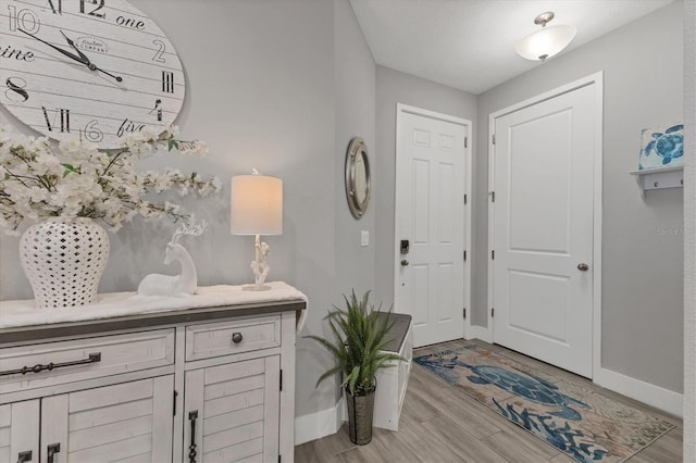 foyer with baseboards and light wood finished floors