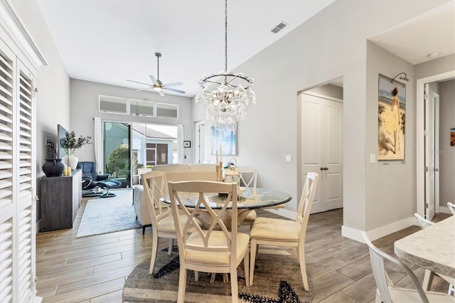 dining area with ceiling fan with notable chandelier, light wood-type flooring, visible vents, and baseboards