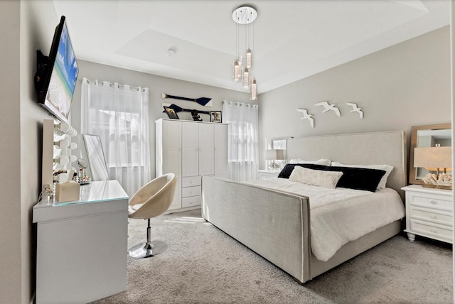 carpeted bedroom with a tray ceiling