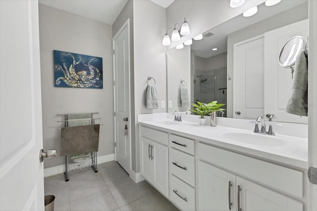 full bathroom with a shower stall, double vanity, a sink, and tile patterned floors