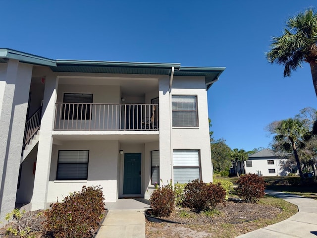 view of property featuring a balcony and stucco siding