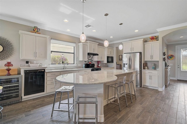 kitchen with wine cooler, a center island, hanging light fixtures, white cabinetry, and black appliances