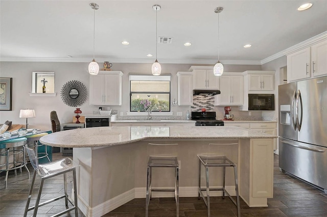 kitchen with black appliances, a kitchen island, white cabinets, and a kitchen breakfast bar