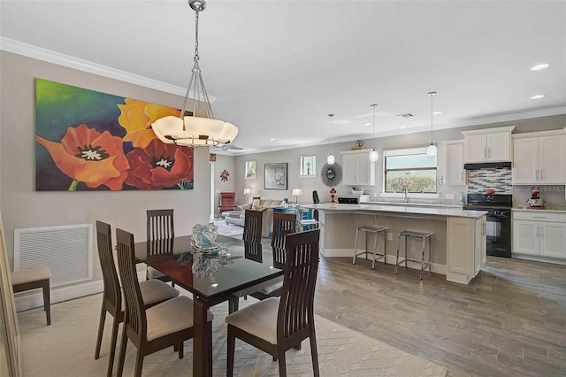 dining area featuring recessed lighting, visible vents, crown molding, and wood finished floors