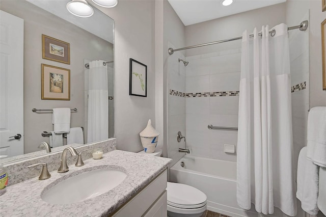 bathroom featuring toilet, shower / bath combo with shower curtain, and vanity