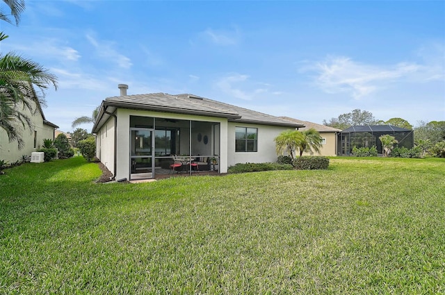 back of property featuring stucco siding and a yard