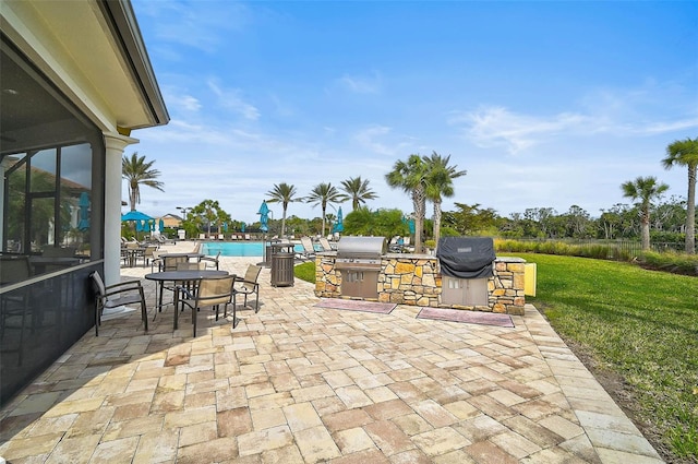 view of patio with area for grilling and a community pool