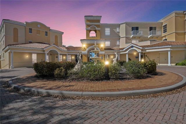 view of front of home featuring a garage, a tiled roof, decorative driveway, and stucco siding