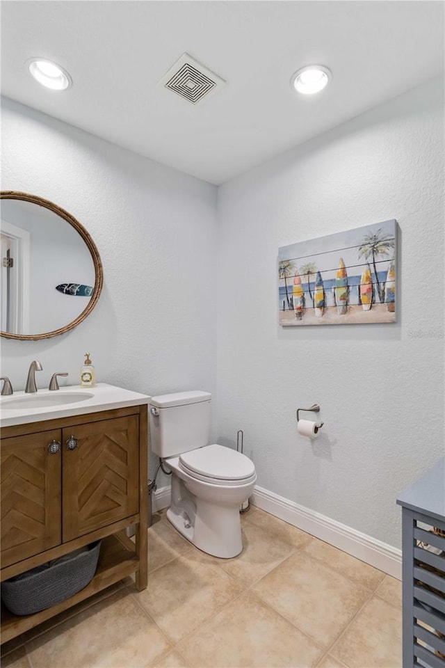 bathroom with tile patterned flooring, toilet, vanity, visible vents, and baseboards